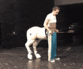 a man is standing next to a centaur with a leash on it
