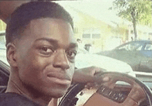 a man is sitting in the driver 's seat of a car .