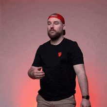 a man with a beard wearing a black t-shirt with a red emblem that says army on it