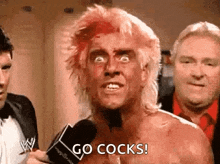 a man with blood on his face is talking into a microphone and says `` go cocks '' .