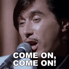 a man singing into a microphone with the words come on come on written below him