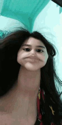 a woman with long hair is making a funny face with her neck .