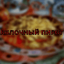 a blurry picture of food with the words яблочный пирог in red