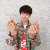 a young man wearing a plaid shirt with the word supreme on it