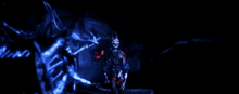 a person in a mask is standing in a dark room with a blue light behind them