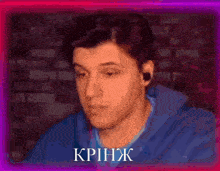 a man in a blue hoodie is surrounded by a pink and purple background with the word krinjak written in white letters