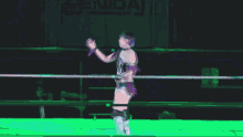 a woman is standing in a wrestling ring with a cameraman taking a picture .