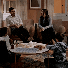 a family sits around a table in a living room talking