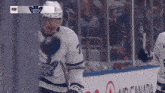 a toronto maple leafs hockey player is standing on the ice