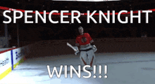 a hockey goalie holding a sword on the ice with the words spencer knight wins below him