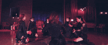 a group of women are dancing in a circle in a room