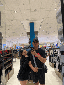 a man and a woman are posing for a picture in a store with the words " i miss you " below them