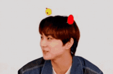 a young man with a red flower on his head
