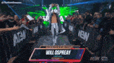 a wrestler named will ospreay is walking through a crowd of people