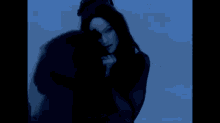 a silhouette of a woman in a black dress is standing in the dark .
