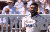 a man wearing a white shirt that says " dream 11 " on it
