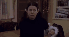 a woman in a black sweater is sitting at a table .