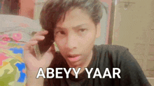 a young man talking on a cell phone with abeyy yaar written on the bottom right