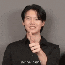 a young man is pointing at the camera with his finger .