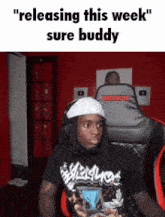 a man wearing headphones and a black shirt says " releasing this week "