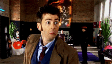 a man in a suit and tie stands in a room