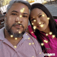 a man and a woman are posing for a picture with hearts around their faces ..