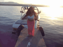 a woman is standing on a dock next to a boat that says yamaha