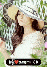 a woman wearing a hat with a heart in the lower right corner of the picture