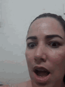 a woman is making a surprised face with her mouth open .