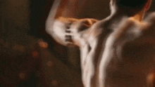 a man without a shirt is flexing his muscles in a blurry photo .