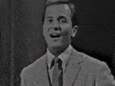 a black and white photo of a man in a suit and tie