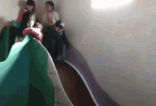 a group of people are playing on a slide .
