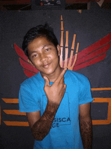 a man wearing a blue shirt that says sisca ge