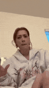 a woman wearing a white sweatshirt with the letter a on the front