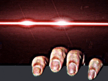 a close up of a person 's fingers with a red light behind it