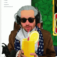 a man wearing a wig and sunglasses holds a glass of orange juice with a straw