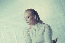 a woman in a white jacket is standing in a fog