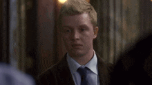 a man in a suit and tie looks at something