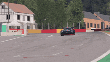 a race car is driving down a track with a red and yellow barrier behind it