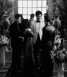 a black and white photo of a group of people standing in a room