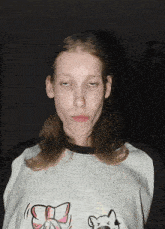 a woman wearing a shirt with a bow on it looks tired
