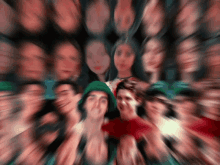 a blurry picture of a group of people including a man in a green hat