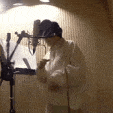 a man in a white sweater stands in front of a microphone