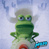 a green frog is sitting on a white object with mojo swoptops written on it
