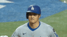 a close up of a baseball player wearing a la hat and jersey