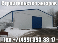 a large white building with a blue door is surrounded by snow .