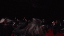 a group of people are dancing in a dark room and one of them is wearing a shirt with the number 25 on it