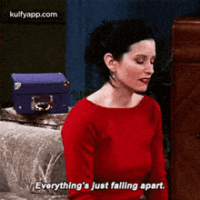 a woman in a red shirt is sitting on a couch and saying `` everything 's just falling apart '' .