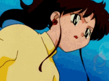 a close up of a girl 's face with a yellow shirt