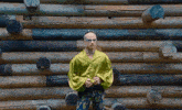 a man wearing sunglasses and a crown stands in front of a wooden wall